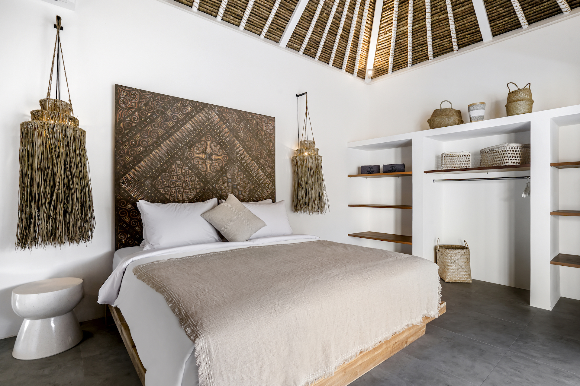 Double bed bedroom with Balinese handicrafts around at Cocotier Seminyak villa, walking distance to Seminyak beach Bali