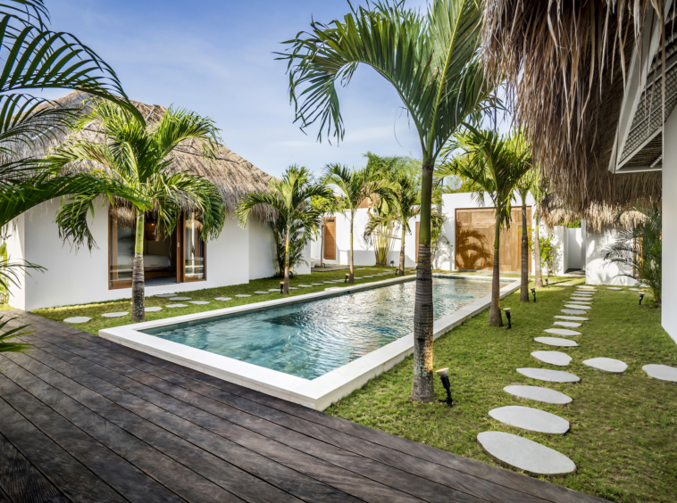 Garden, palm trees, and pool area at Cocotier Seminyak Villa, walking distance to Seminyak beach Bali only